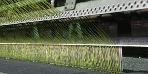 Hierba artificial de fútbol premium 11000 Dtex con agujeros de drenaje de perforación y resistencia a los rayos UV